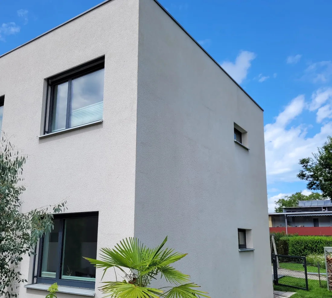 Dasselbe Einfamilienhaus nach der Fassadenreinigung mit sauberem, hellem Putz