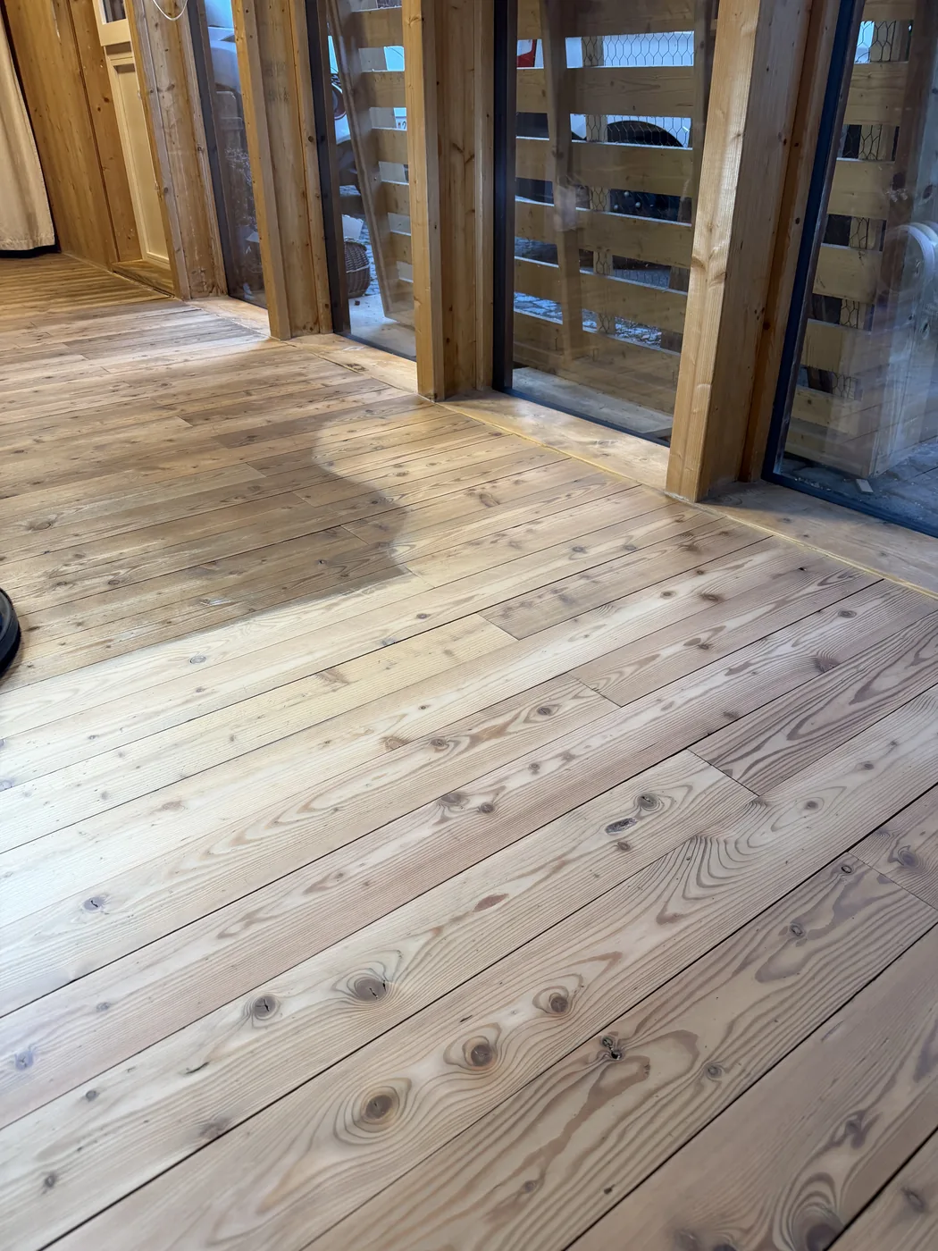 Frisch geschliffene helle Dielen in einem Wohnraum mit Holzverkleidung