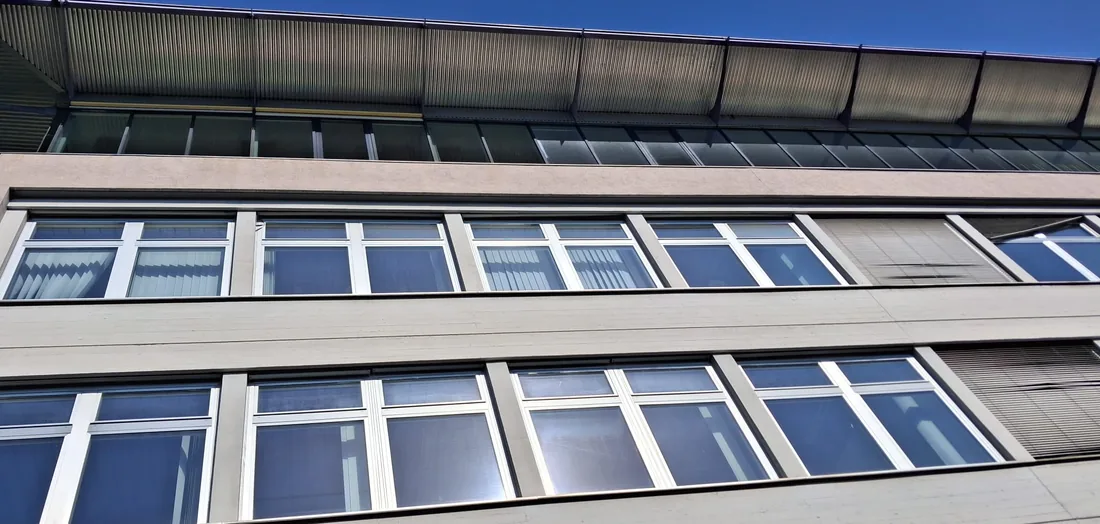 Fensterbänder eines Bürogebäudes nach der Glasreinigung vor tiefblauem Himmel